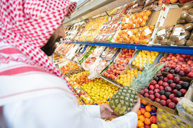  رجل عربي سعودي خليجي في قسم الفواكه داخل السوبرماركت ، الاحتياجات المنزلية ، السلع والمواد الغذائية ، متعة التسوق.