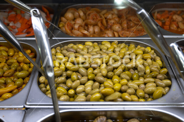 صورة مقربة لانواع الزيتون في المتجر، وجبات صحية ، حبات الزيتون ، السلع والمواد الغذائية ، وجبة خفيفة ، تشكيلة من المقبلات الباردة المشكلة.