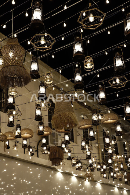 انوار الزينة الرمضانية المعلقة في الشوارع ليلا، زينة رمضان، فوانيس رمضان، مصابيح مضيئة، احبال الانارة، مصابيح معدنية، اجواء رمضانية