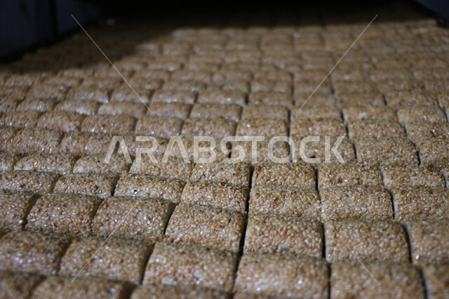 صورة مقربة لمعجنات العيد المحشوة بالتمر، اصابع التمر بالسمسم، الحلويات الشعبية الهشة، كعك العيد اللذيذ، مخبوزات طازجة، حلويات طازجة، معجنات العيد