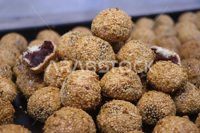 صورة مقربة لكرات التمر بالسمسم، معجنات العيد اللذيذة، الحلويات الشعبية الهشة، حلوى العيد، مخبوزات طازجة، حلويات طازجة