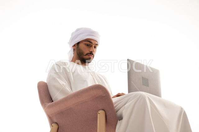 بورتريه لرجل عربي خليجي إماراتي يجلس على كرسي , استخدم جهاز الحاسوب، اجراء مكالمات فيديو،  محادثات ودردشة، تواصل اجتماعي ، التواصل مع الأصدقاء، اجتماع عمل عن بعد،  تصفح الانترنت ، خلفية بيضاء .