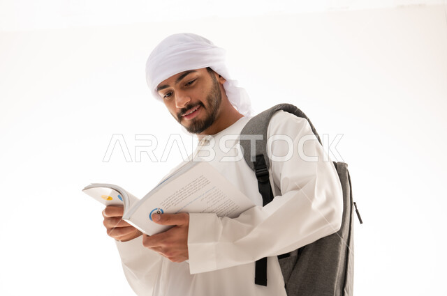 بورتريه لطالب جامعي عربي خليجي اماراتي بالزي الاماراتي التقليدي يحمل حقيبة على ظهره , الذهاب للجامعه ، مفهوم التعليم الجامعي , القراءة والثقافة ,  خلفية بيضاء