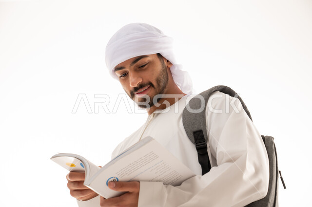 بورتريه لطالب جامعي عربي خليجي إماراتي بالزي الاماراتي التقليدي يحمل حقيبة على ظهره , الذهاب للجامعه ، مفهوم التعليم الجامعي , القراءة والثقافة ,  خلفية بيضاء