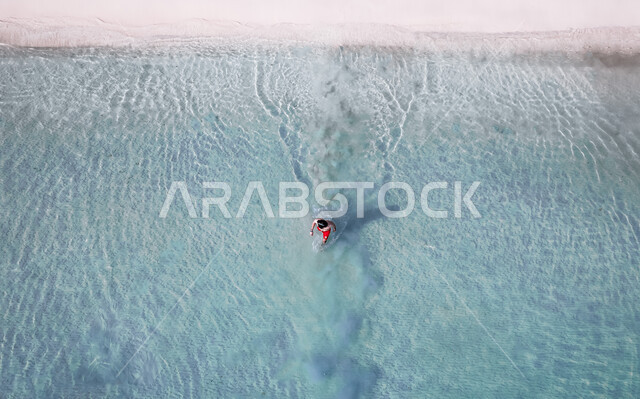 صورة من الاعلى لرجل يستعد لدخول البحر، شاطئ البحر، رمال البحر الناعمة، مناظر طبيعية، اماكن سياحية