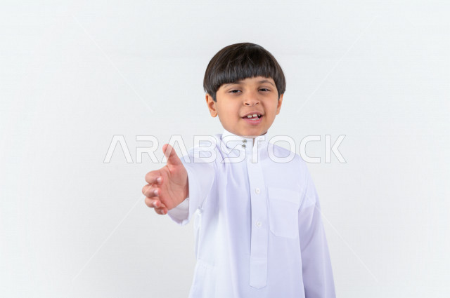 بورتريه لطفل عربي سعودي خليجي يرتدي الثوب السعودي, إيماءات يد تدل على المصافحه, التحيه والسلام, الموافقه والقبول, تعارف و صداقه, الشعور بالإيجابيه, الرضى والسرور