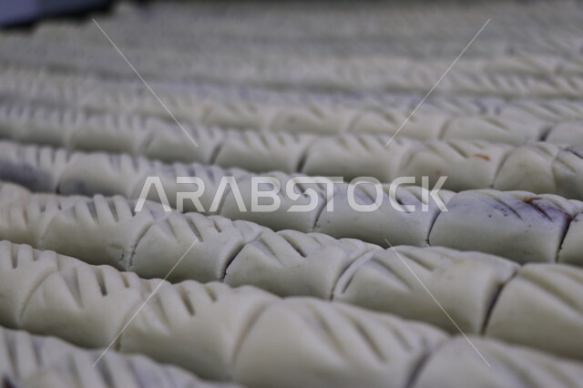 قطع من البسكويت المقرمش المحشو بالعجوة الطازجة , معمول بالتمر الطبيعي , حلويات وسكريات , مخبوزات هشة وطرية , كعك العيد , صناعة الحلوى  .