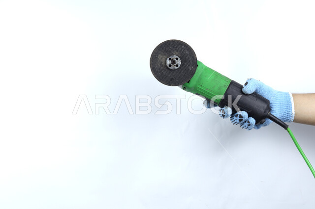 يد تمسك آلة طاحونة الزوايا  , شفرة دائرية , آلات ومعدات ,  هندسة معمارية , أدوات بناء , خلفية بيضاء .