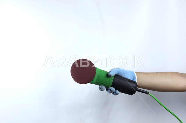 يد تمسك آلة طاحونة الزوايا , هندسة معمارية , أدوات بناء , آلات ومعدات , خلفية بيضاء .