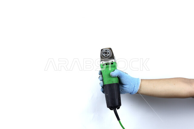 يد تمسك آلة طاحونة الزوايا , هندسة معمارية ,  آلات ومعدات ,أدوات بناء , خلفية بيضاء .