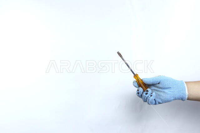 يد تمسك مفك براغي  ,أدوات بناء ,   آلات ومعدات , هندسة معمارية , خلفية بيضاء .