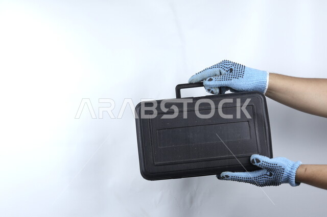 يد تمسك حقيبة معدات يدوية  ,أدوات بناء ,   آلات ومعدات , هندسة معمارية , خلفية بيضاء .