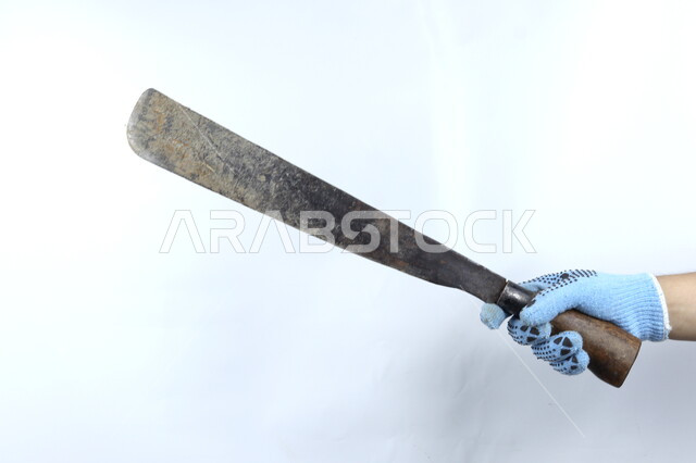 يد تمسك منجل حديدي ,أدوات بناء ,   آلات ومعدات , هندسة معمارية , خلفية بيضاء .