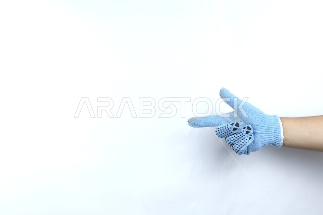 صورة مقربة ليد بقفازات زرقاء  , خمسة اصابع , ايماءات يد تدل على رقم اثنين ,  رموز وايماءات مختلفة  , خلفية بيضاء .