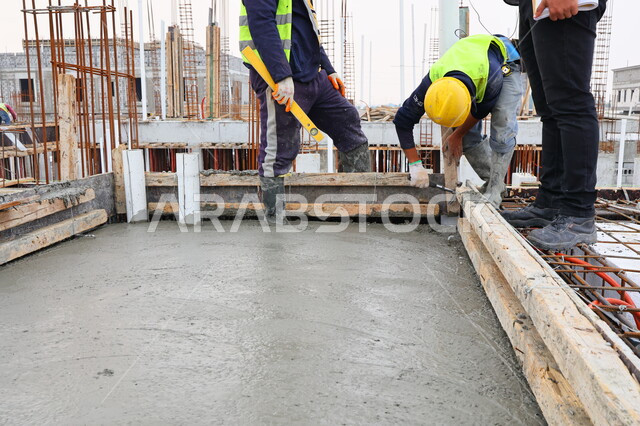 عمال البناء يقومو باختبار الاسقف، اعمال بناء الاسقف، معدات وادوات البناء، ادوات اختبار صب الاسقف، اسياخ معدنية، الحديد الصلب، صبة الخرسانة