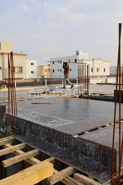 عمال البناء يقومو باعمال بناء الاسقف، تركيب خشب الاسقف، معدات وادوات البناء، اعمال البناء، اسياخ معدنية، الحديد الصلب، تجهيز الاسياخ لبناء الاسقف