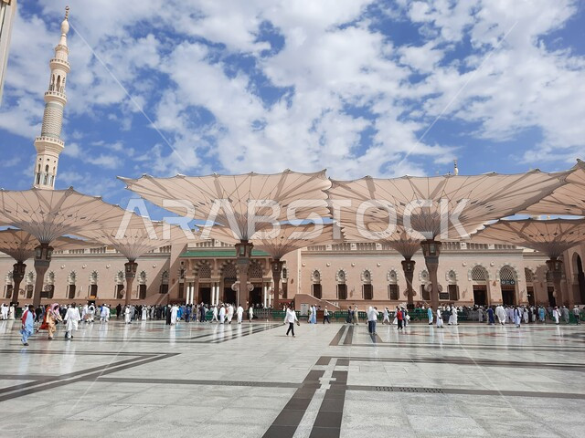 ساحة المسجد النبوي الشريف في المدينة المنورة في المملكة العربية السعودية، العبادة والتقرب الى الله ، الحرم النبوي الشريف، أماكن إسلامية مقدسة، تجمع المسلمون في المجمع الخارجي للمسجد النبوي في المدينة المنورة، المظلات الإلكترونية، معالم دينية إسلامية.