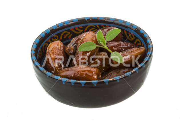 طبق من حبات التمر الصحي ، وجبة ذات قيمة غذائية عالية  ، ضيافة رمضانية ، تمور صحية ولذيذة , خلفية بيضاء .