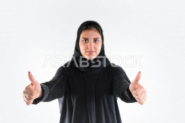 بورتريه لمرأه عربيه سعوديه خليجيه ترتدي العباءة والحجاب , إيماءات وجه ويدين تدل على الإعجاب والرضى, علامة الجوده, الإمتياز والتميز, حالة جيده, القبول والموافقه , خلفية بيضاء .