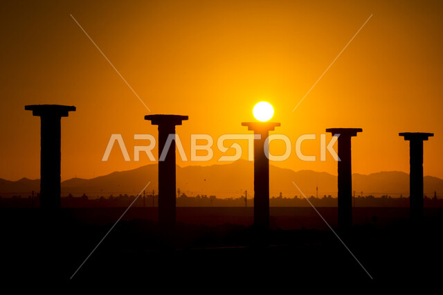 صورة ظلية للأعمدة أثناء غروب الشمس, اللون البرتقالي لغروب الشمس, خلفية الطبيعة .
