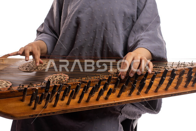 Portrait close to a Saudi Arab Gulf woman, artist using a stringed musical instrument, playing the qanun, presenting programs, musical arts and theatrical art, musical artistic talents, practicing Saudi folk arts, white background