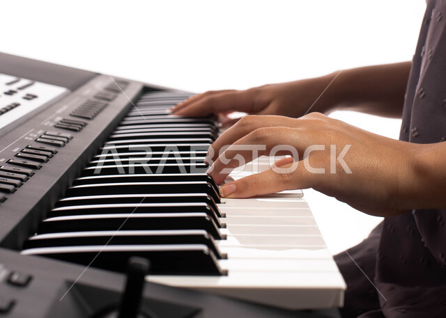 تقديم البرامج والفنون الموسيقية والفن المسرحي، بورتريه مقرب لامرأة خليجية سعودية عربية فنانة تجلس امام آلة البيانو الموسيقية ويستمتع بالعزف، مواهب فنية موسيقية، قضاء الوقت بالعزف على آلة البيانو، الطرب والانشطة ترفيهية، خلفية بيضاء