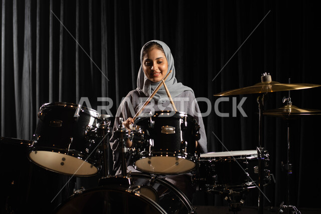 تقديم البرامج والفنون الموسيقية والفن المسرحي، ممارسة هواية الطبل على آلة الطبول الالكترونية، امرأة عربية سعودية خليجية فنانة تقوم بقرع الطبول، مواهب فنية موسيقية، استخدام الآلات الايقاعية، أنشطة ترفيهية