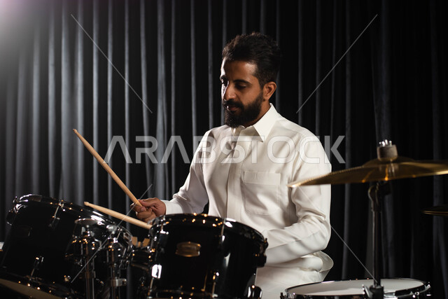 تقديم البرامج والفنون الموسيقية والفن المسرحي، ممارسة هواية الطبل على آلة الطبول الالكترونية، رجل عربي سعودي خليجي فنان يقوم بقرع الطبول، مواهب فنية موسيقية، استخدام الآلات الايقاعية، أنشطة ترفيهية