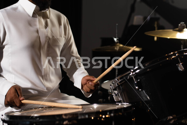 قرع الطبول باستخدام الآلات الايقاعية، مواهب فنية موسيقية، صورة مقربة رجل عربي سعودي خليجي فنان يقوم بممارسة هواية الطبل على آلة الطبول الالكترونية، تقديم البرامج والفنون الموسيقية والفن المسرحي، أنشطة ترفيهية