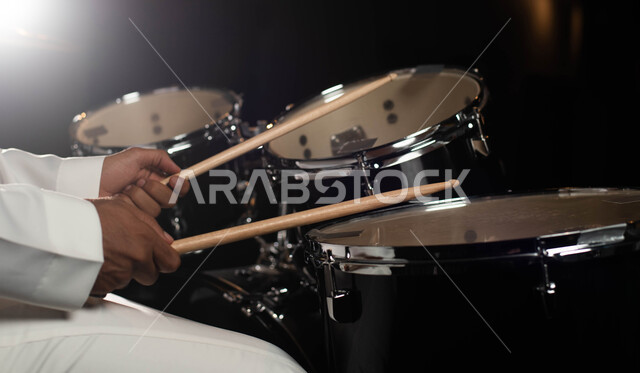 قرع الطبول باستخدام الآلات الايقاعية، مواهب فنية موسيقية، صورة مقربة رجل عربي سعودي خليجي فنان يقوم بممارسة هواية الطبل على آلة الطبول الالكترونية، تقديم البرامج والفنون الموسيقية والفن المسرحي، أنشطة ترفيهية