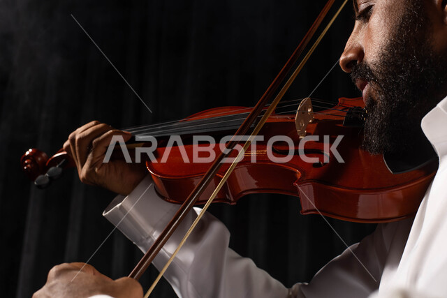 مواهب فنية موسيقية، استخدام الآلات الموسيقية الوترية، رجل فنان عربي خليجي سعودي يمارس هواية العزف باستخدام آلة الكمان، تقديم البرامج والفنون الموسيقية والفن المسرحي، العزف على آلة الكمان، جلسة وناسة وطرب، انشطة ترفيهية