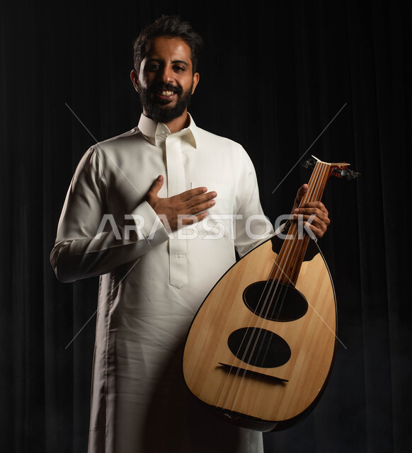 استخدام آلة العود الوترية في تقديم البرامج والفنون الموسيقية والفن المسرحي، عازف سعودي خليجي عربي يقوم بالقاء التحية للجماهير على المسرح، ممارسة هواية العزف على آلة العود، مواهب فنية موسيقية