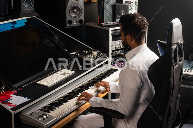 Sound and music adjustment devices, musical artistic talents, a Saudi Arabian Gulf man, an artist who sits in front of the piano and enjoys playing, presenting programs, musical arts and theatrical art, spending time playing the piano