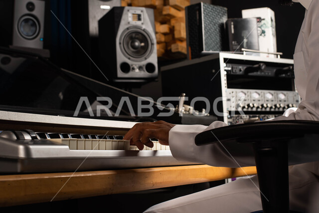 تقديم البرامج والفنون الموسيقية والفن المسرحي، اجهزة تعديل الصوت والموسيقى، مواهب فنية موسيقية، صورة مقربة لرجل خليجي سعودي عربي فنان يجلس امام آلة البيانو الموسيقية ويستمتع بالعزف، قضاء الوقت بالعزف على آلة البيانو