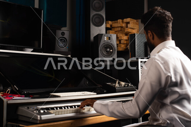 Musical talents, sound and music adjustment devices, a Saudi Arabian Gulf man, an artist who sits in front of the piano and enjoys playing, presenting programs, musical arts and theatrical art, spending time playing the piano