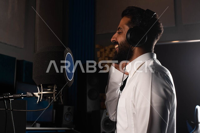 رجل خليجي سعودي عربي فنان داخل استديو التسجيل الصوتي، مواهب فنية موسيقية، الاستمتاع بتقديم البرامج والفنون الموسيقية والفن المسرحي، الاذاعة الصوتية والغناء والطرب