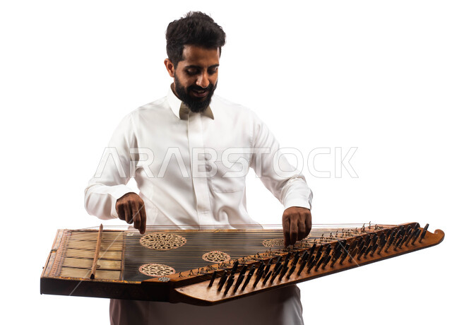 Using stringed musical instruments, musical artistic talents, a portrait of a Saudi Arabian Gulf man, an artist playing the qanun, presenting programs, musical arts and theatrical art, practicing Saudi folk arts, white background