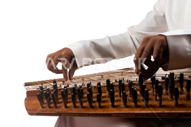 بورتريه مقرب لرجل خليجي عربي سعودي فنان يستخدام آلة موسيقية وترية، العزف على آلة القانون، تقديم البرامج والفنون الموسيقية والفن المسرحي، مواهب فنية موسيقية، ممارسة الفنون الشعبية السعودية، خلفية بيضاء