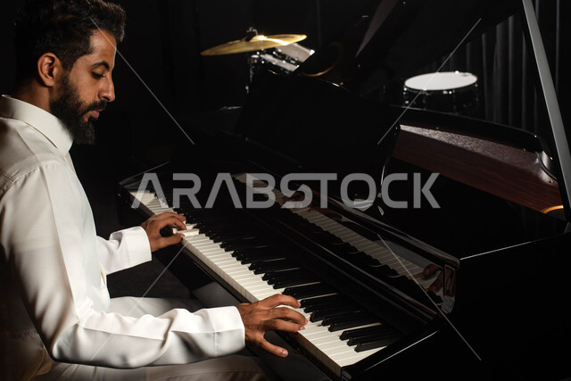 Musical artistic talents, a Saudi Arabian Gulf man, an artist who sits in front of the piano and enjoys playing, presenting programs, musical arts and theatrical art, spending time playing the piano, singing and entertainment activities