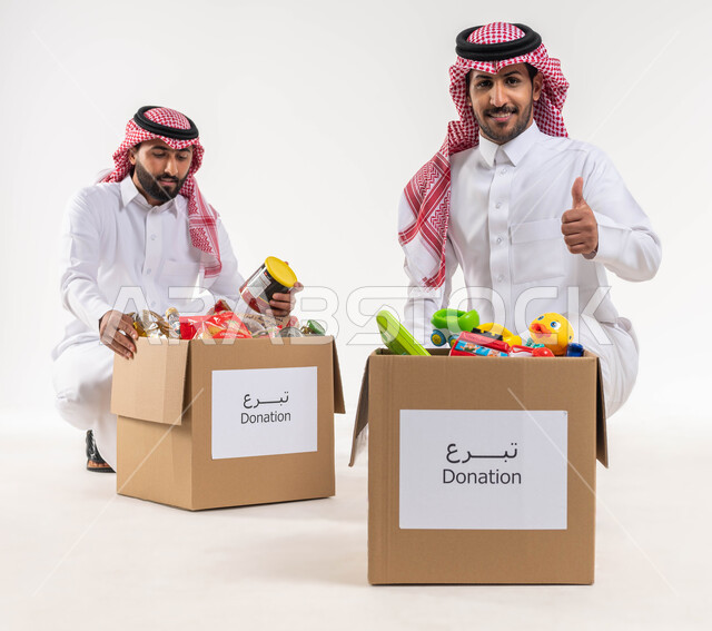 رجلان عربيان خليجيان سعوديان، بورتريه لرجل يرفع اصبع السبابة بايماءات تدل على الاعجاب والقبول والموافة، صندوق مليئ بالعاب الاطفال، التبرع لمشروع السلة الغذائية، مبادرات وتبرعات انسانية خيرية، جمعيات اسلامية في السعودية، شهر رمضان، خلفية بيضاء