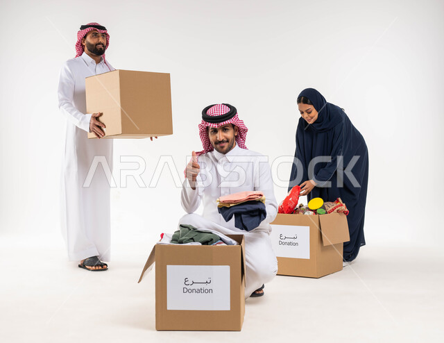 بورتريه لمجموعة من المتطوعيين العرب السعوديين الخليجيين يقومون بجمع وتوزيع صناديق التبرعات للمحتاجين، ترتيب ملابس وهدايا العيد السعيد، مبادرات وتبرعات انسانية خيرية، جمعيات اسلامية في السعودية، خلفيه بيضاء