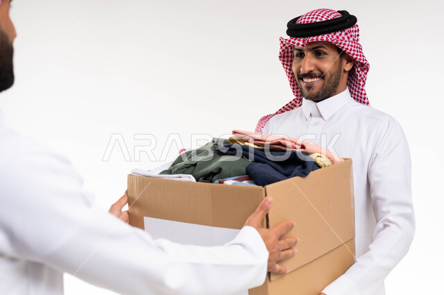 جمع وتوزيع التبرعات الخيرية ، خدمة المجتمع السعودي المتعفف ، بورتريه مقرب لرجل عربي خليجي سعودي يقدم  صندوق تبرعات الملابس الفائضه ، اهداء ملابس العيد للمحتاجين ، جمعيات خيرية ومبادرات انسانية ، خلفية بيضاء.