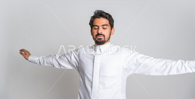 بورتريه لرجل عربي سعودي خليجي باللباس التقليدي السعودي , إيماءات وجه ويدين تدل على النعاس , الإحساس بالتعب والتثاؤب , الحاجة للنوم والراحة , الكسل والخمول ,خلفية بيضاء .