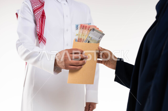 بورتريه مقرب لرجل سعودي عربي خليجي  يرتدي الزي التقليدي يقدم المساعدة لسيدة متعففة ، اخراج زكاة المال للمحتاجين ، جمعيات خيرية في السعودية ، الصدقة في شهر رمضان ، العبادة والتقرب الى الله ، خلفية بيضاء.