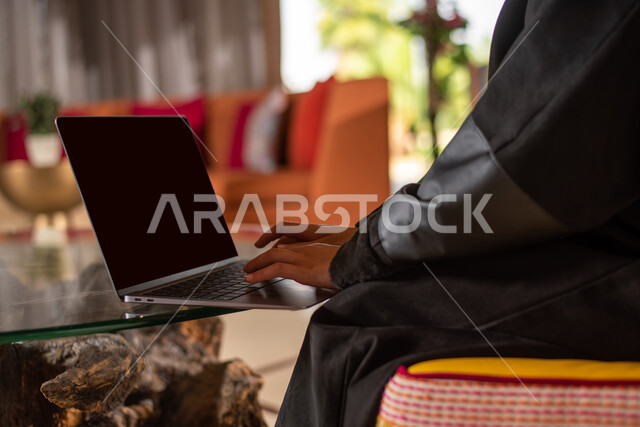 انجاز مهام العمل ، شابة عربية سعودية خليجية تستخدم الحاسوب المحمول ، العمل عن بعد ، التواصل مع العملاء ، التسويق الالكتروني ، تصفح الانترنت  واستخدام تقنيات حديثة