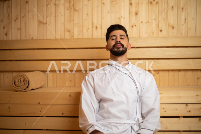 الاهتمام والعناية بالمظهر، منتجعات صحية للعناية الصحية والبدنية ، شاب سعودي مستمتع في احدى مراكز السبا بالسعودية يحصل على قسط من الراحة و الاسترخاء في مرافق المنتجع  ،الاسترخاء في غرفة الساونا ،  الرفاهية والدلال، صالون وسبا رجالي