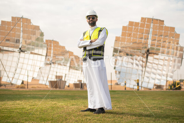 مهندس عربي خليجي سعودي، يرتدي الخوذة وسترة الحماية، ، التدقيق والإشراف على العمل، مفهوم هندسة الطاقة، مهن ووظائف سعودية، توليد الكهرباء عبر محطات الطاقة الشمسية، الواح الطاقة الطبيعية المتجددة .