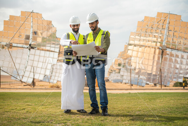 تطور التقنية والتكنولوجيا ,مهندسان عربيان خليجيان سعوديان يشرفان على محطات الطاقة الشمسية في السعودية، إرتداء خوذة وسترة الحماية الخاصة بالعمل، مخططات وتصاميم هندسية، حوارات ونقاشات عمل ،  محطات الطاقة الشمسية المتجددة، الواح وستلايت انتاج الكهرباء