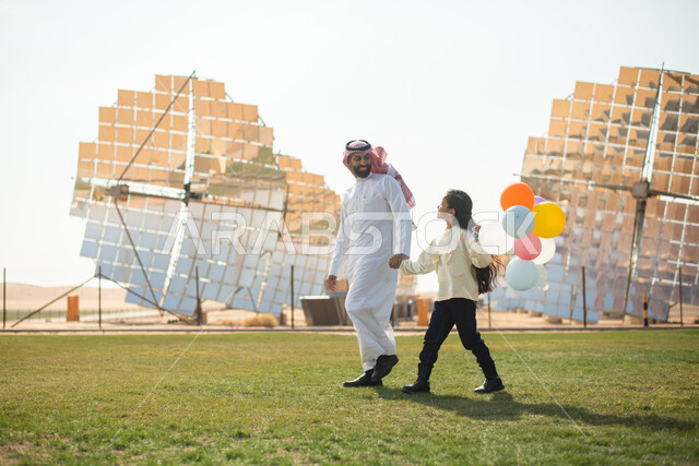 ستلايت وألواح طاقة طبيعية متجددة , رجل عربي خليجي سعودي يقضي وقته مع وابنته ، توليد الطاقة الكهربائية عبر الواح الطاقة الشمسية , صورة الجسم بالطول الكامل , رؤية ومشاريع مستقبلية جديدة .