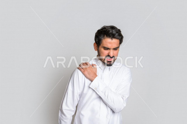 بورتريه لرجل عربي سعودي خليجي يرتدي الثوب السعودي, إيماءات وجه ويدين تدل على الشعور بالصداع, ألم بالرأس, الإحساس بالمرض, التعب والإرهاق, الحاجه للعلاج, طلب المساعده , خلفية بيضاء .